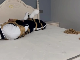 Young Asian scholar tied up with white socks and a gag on his mouth.